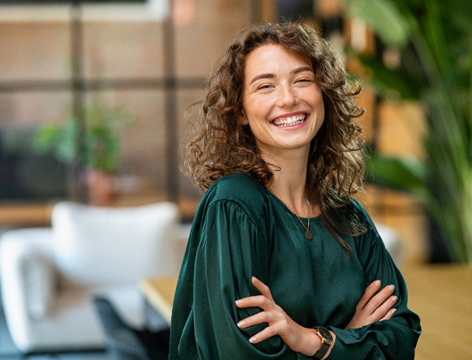 Portrait of smiling, confident woman in green blouse