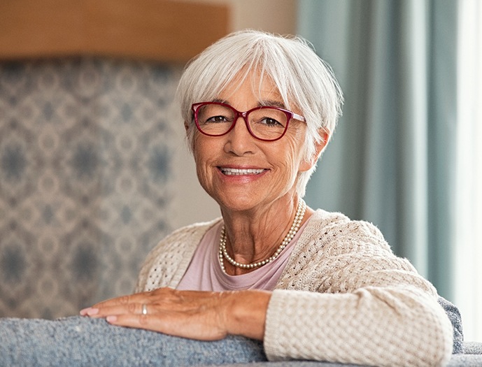 Senior woman sitting on couch smiling