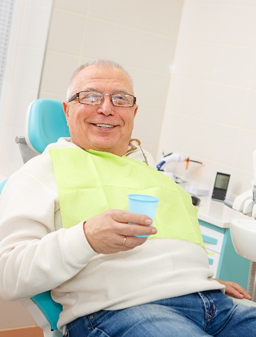Senior man sitting in dental chair for full mouth reconstruction in Grosse Pointe Woods