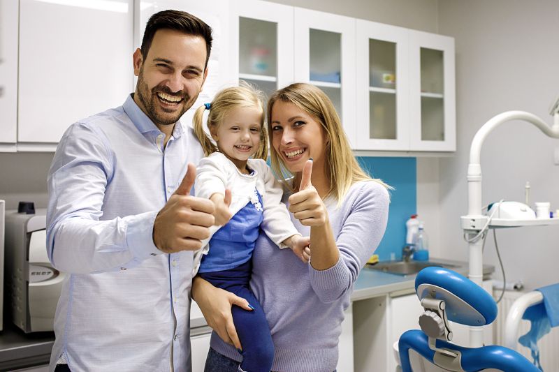 Parents with young daughter in family dental office.